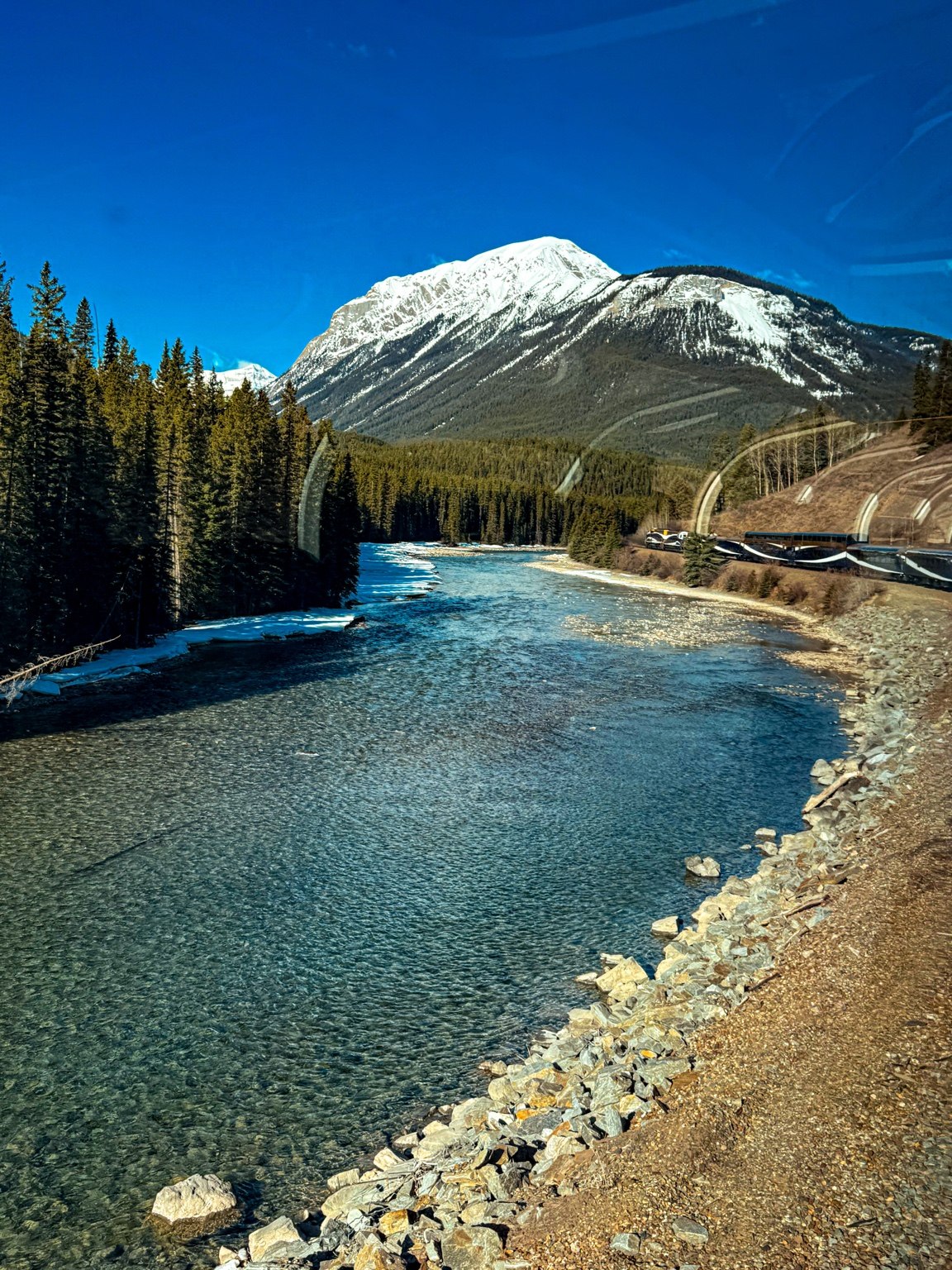 Rocky Mountaineer beside a river in the Canadian Rockies