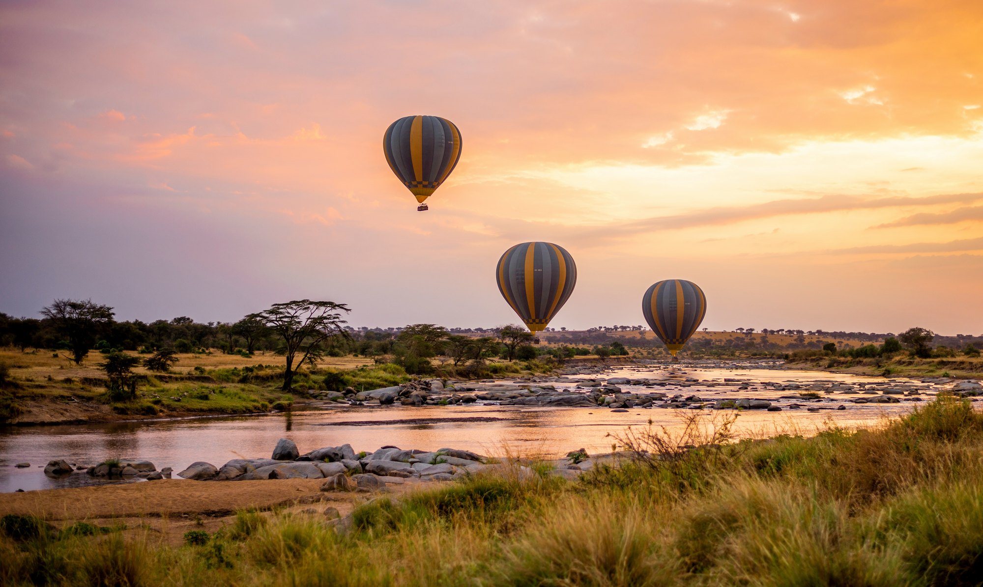 Hot-air balloons over the East African landscape at sunrise