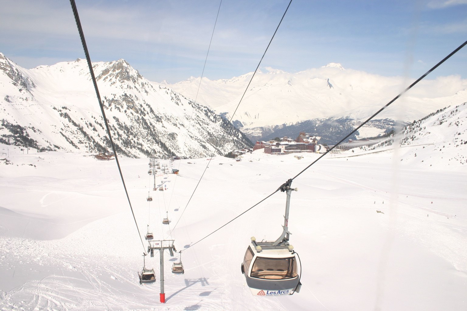 Gondola lift crossing a snow-covered ski area in the European Alps